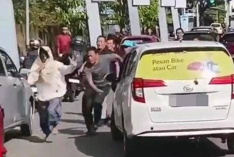 Tangkapan layar seorang pria di Makassar mengenakan kerudung saat membawa kabur mobil milik orang lain/Istimewa