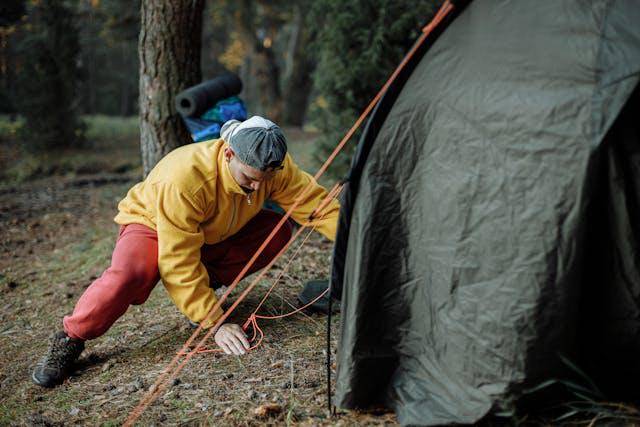 Pria sedang membangun tenda di jalur pendakian (pexels.com/Thirdman)