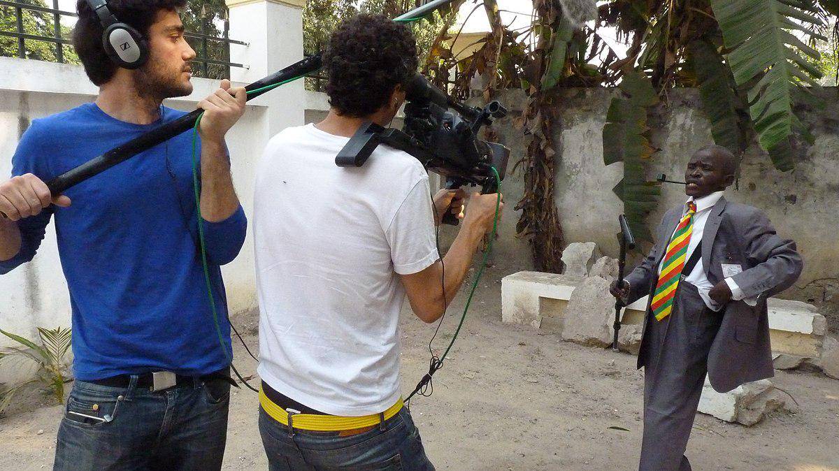 potret seorang sapeur di Brazzaville sedang diwawancarai oleh dua pembuat film Spanyol (commons.wikimedia.org/Enric Bach)