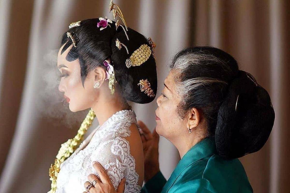 Meniupkan asap rokok kepada pengantin. (Facebook.com/Inspirasi Pernikahan)