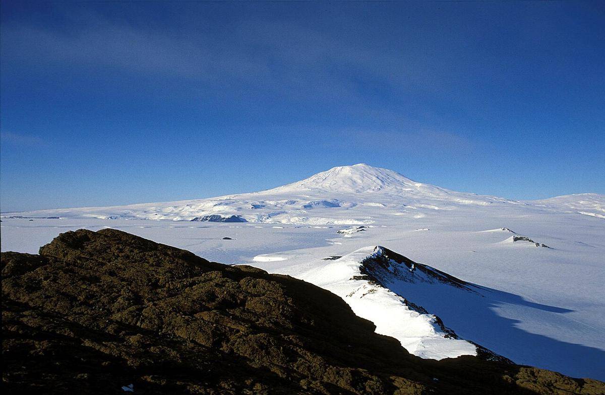 Panorama Pulau Ross terlihat dari Castle Rock, dekat Stasiun McMurdo di Semenanjung Hut Point dengan Gunung Erebus (tengah), Gunung Terror (kanan) dan Lidah Es Erebus di Selat McMurdo yang membeku (kiri), Antartika