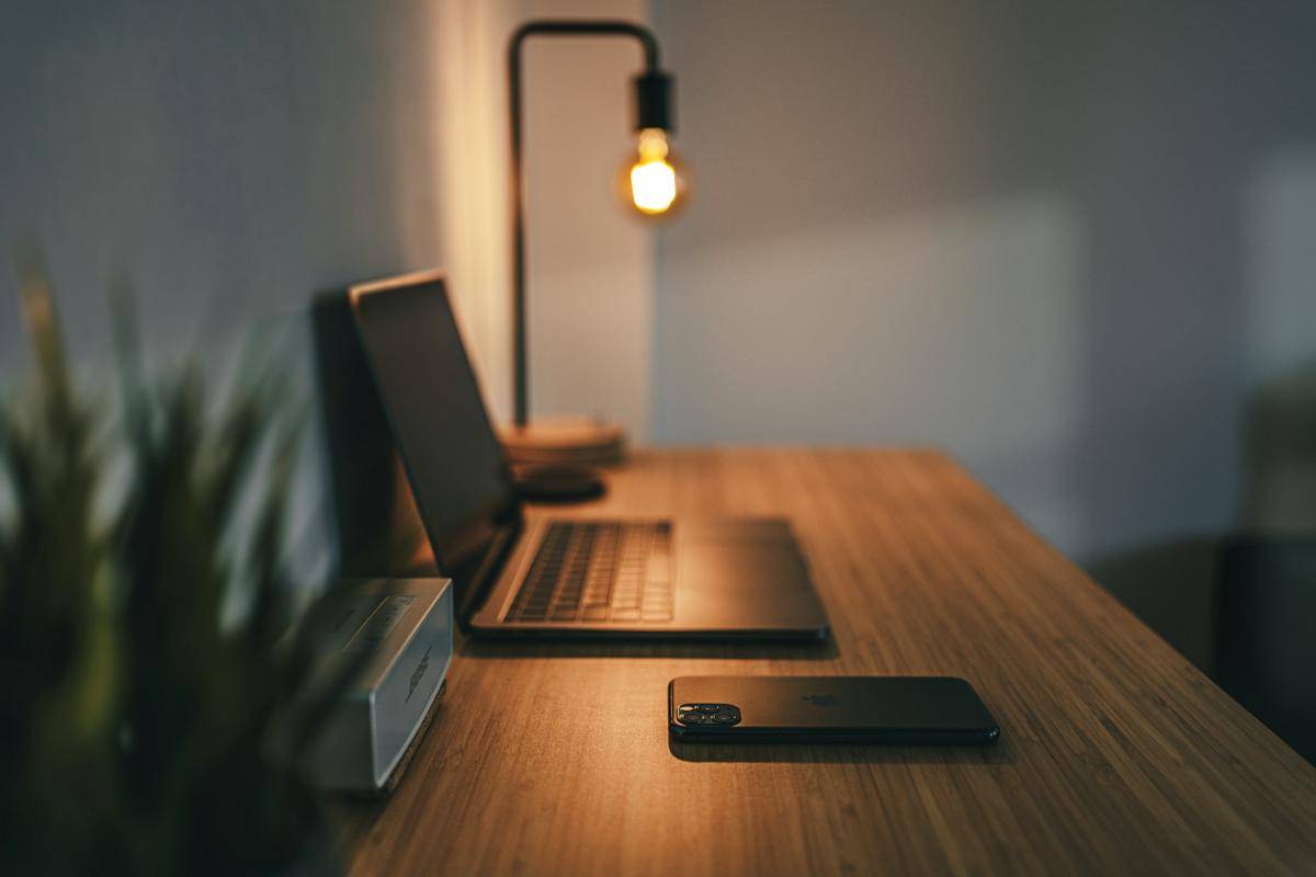Ilustri meja kerja dengan laptop hitam (Unsplash.com/ Remy_Loz)