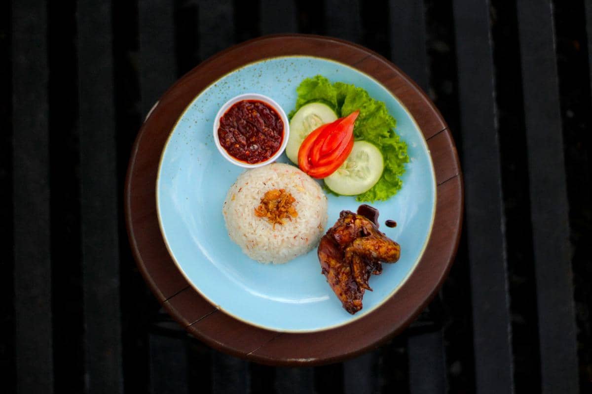 ilustrasi ayam goreng Kalasan lengkap dengan lalapan dan sambal merah 