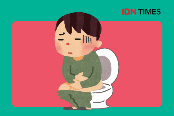 Seorang laki-laki duduk di toilet untuk buang air besar.