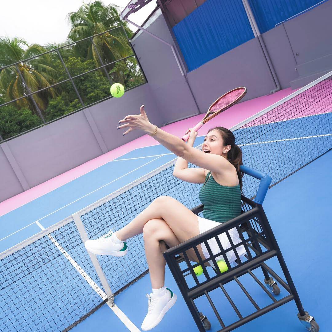 pose Wulan Guritno di atas troli bola tenis 