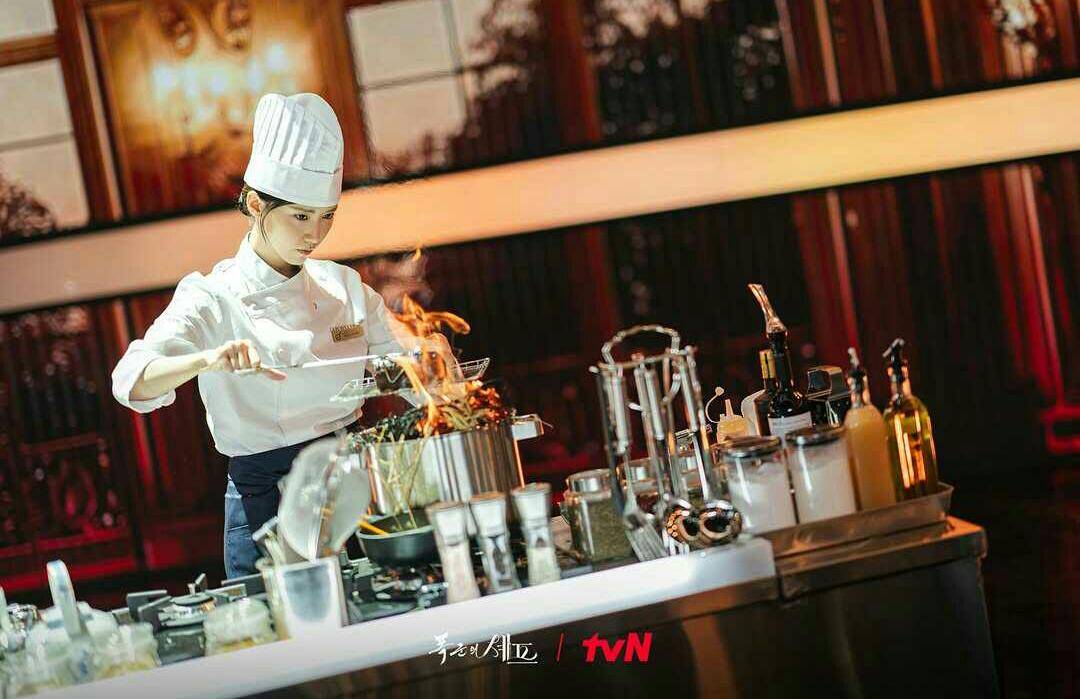 ilustrasi Yeon Ji Yeong memasak dengan teknik flambe di drama Korea Bon Appetit, Your Majesty