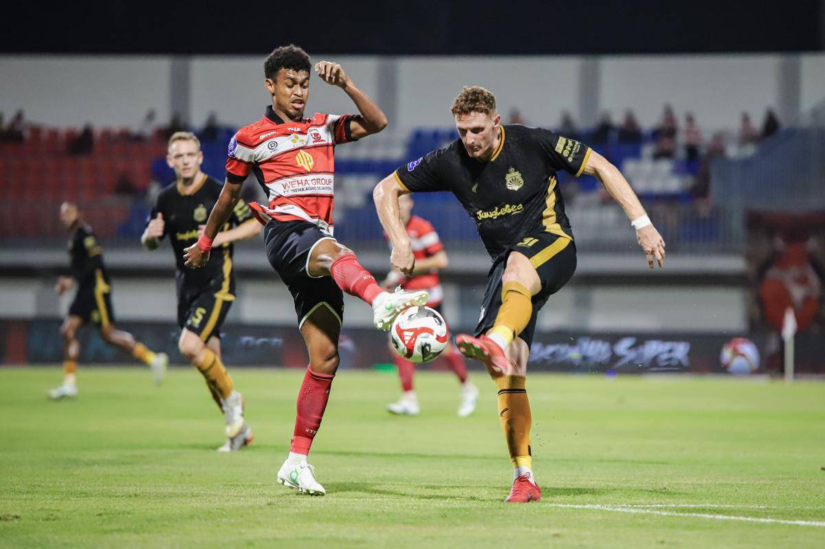 Pesepak bola Madura United Fransiskus Alesandro Nimo (kiri) berebut bola dengan pesepak bola Bhayangkara Presisi Lampung FC Stejepan Plazonja (kanan) pada pertandingan BRI Super League di Stadion Gelora Madura Ratu Pamelingan, Pamekasan, Jawa Timur, Jumat (12/9/2025). (ANTARA FOTO/Rizal Hanafi/foc.)