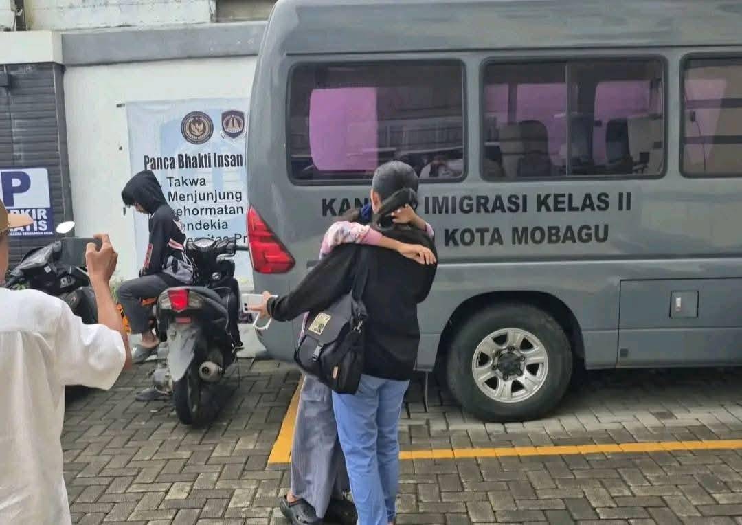WNA asal Filipina, Prescy Sono, memeluk anaknya saat hendak dideportasi. Dok. Kantor Imigrasi Kotamobagu