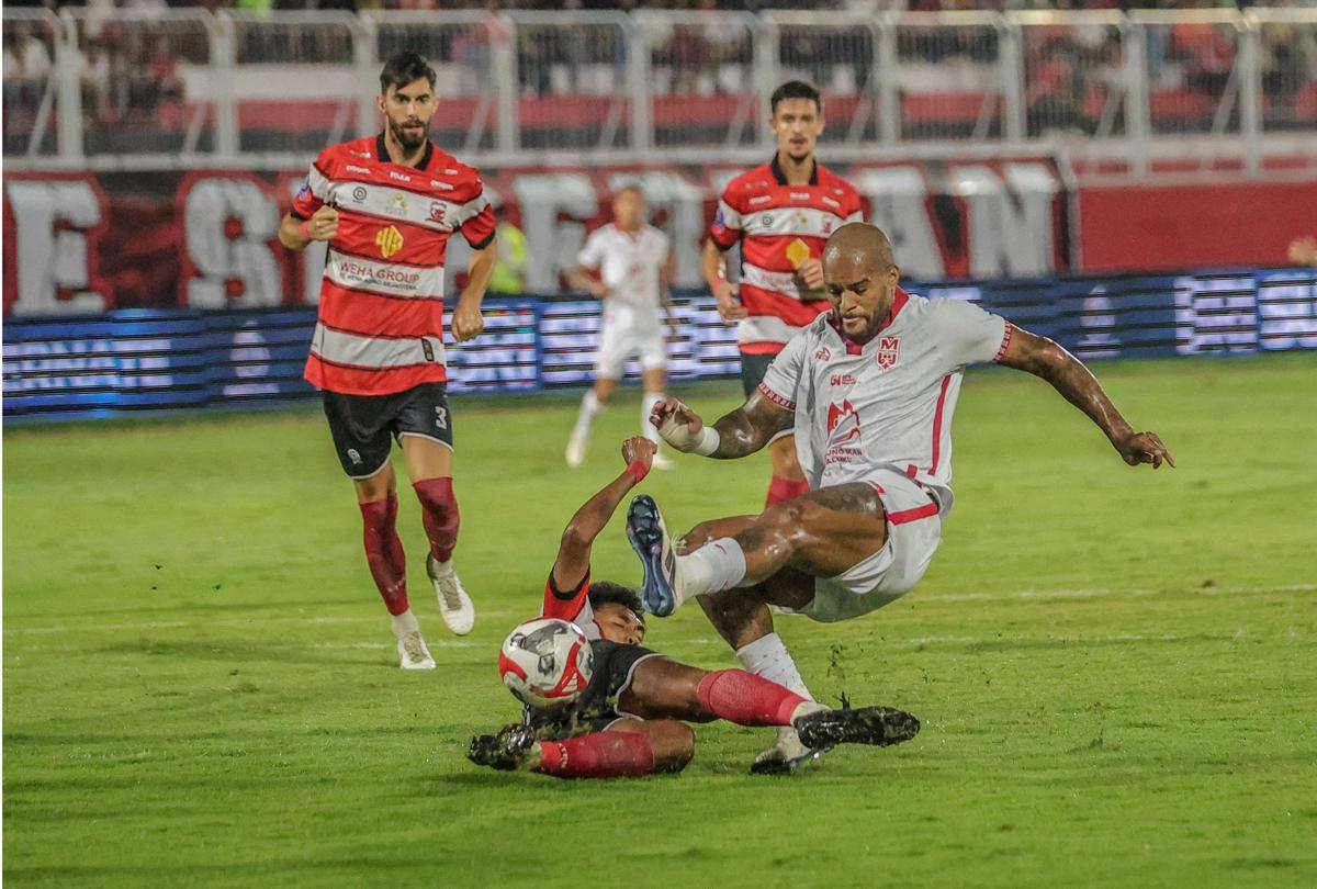 Pesepak bola Malut United David Da Silva (kanan) menendang bola dihadang pesepak bola Madura United Tri Setiawan (kiri) pada pertandingan BRI Super League 2025-2026 di Stadion Gelora Kie Raha Ternate, Maluku Utara, Jumat (19/9/2025). (ANTARA FOTO/Andri Saputra/YU)