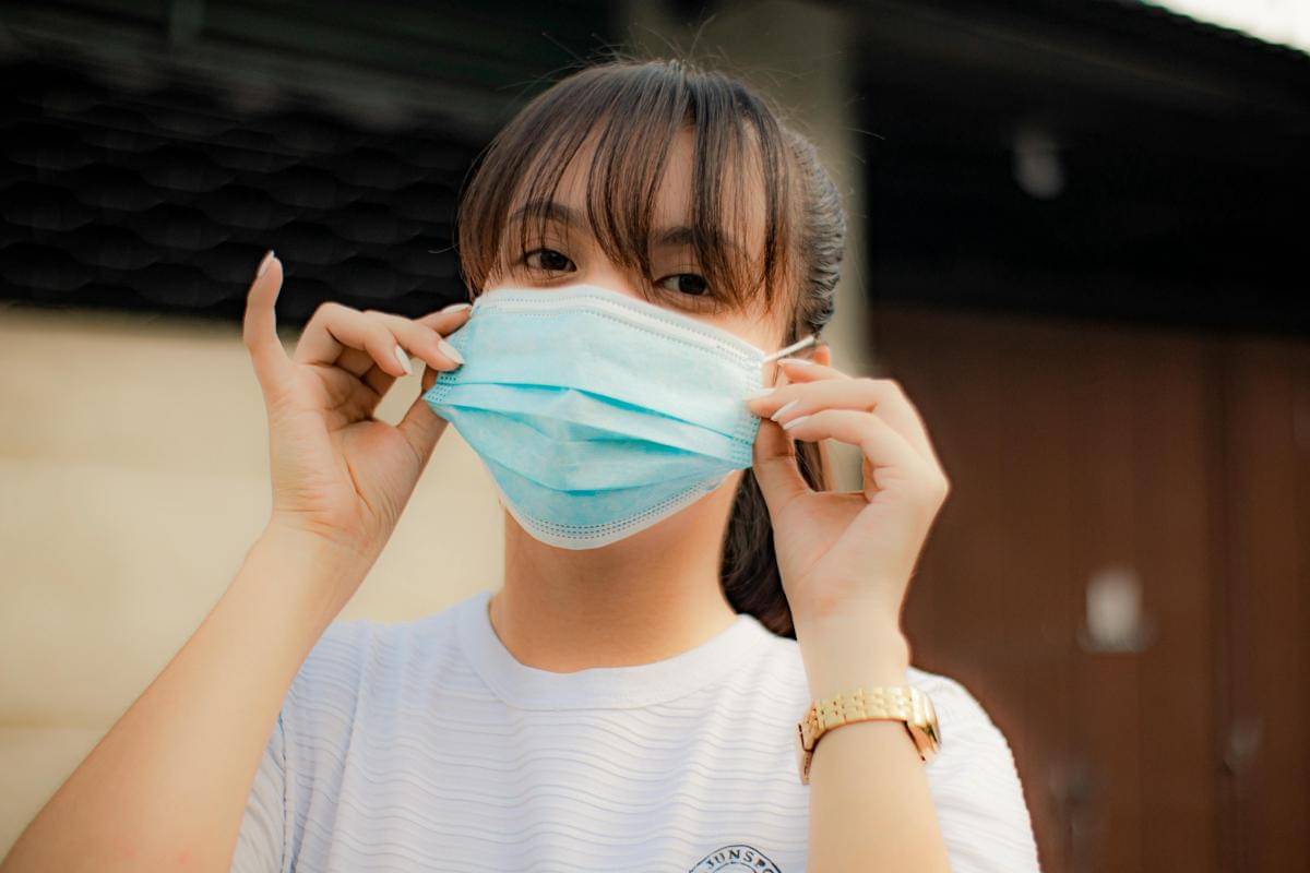 Seorang perempuan memakai masker untuk mencegah penyakit dan melindungi diri dari polusi udara.
