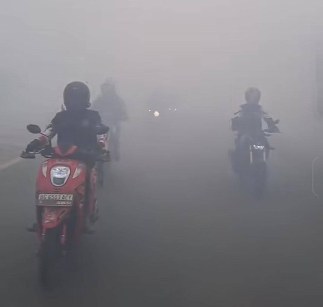 Para pengendara di Jalinsum Ogan Ilir yang diselimuti kabut asap. (Dok. Warga)