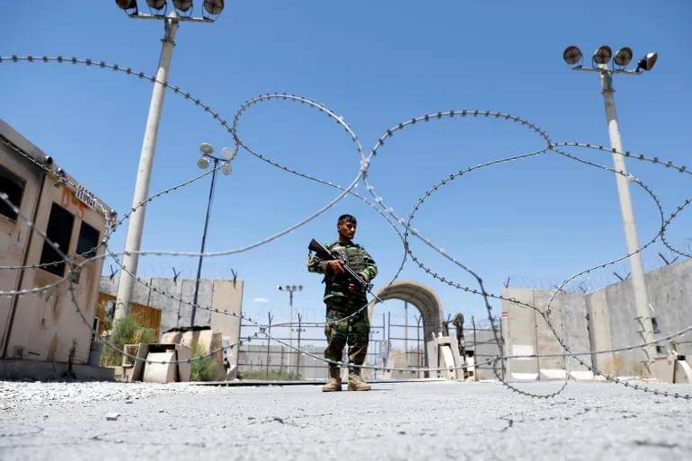 Seorang tentara Afghanistan berjaga di gerbang pangkalan udara Bagram AS di provinsi Parwan pada hari pasukan Amerika terakhir mengosongkannya, 2 Juli 2021 [Mohammad Ismail/Reuters]