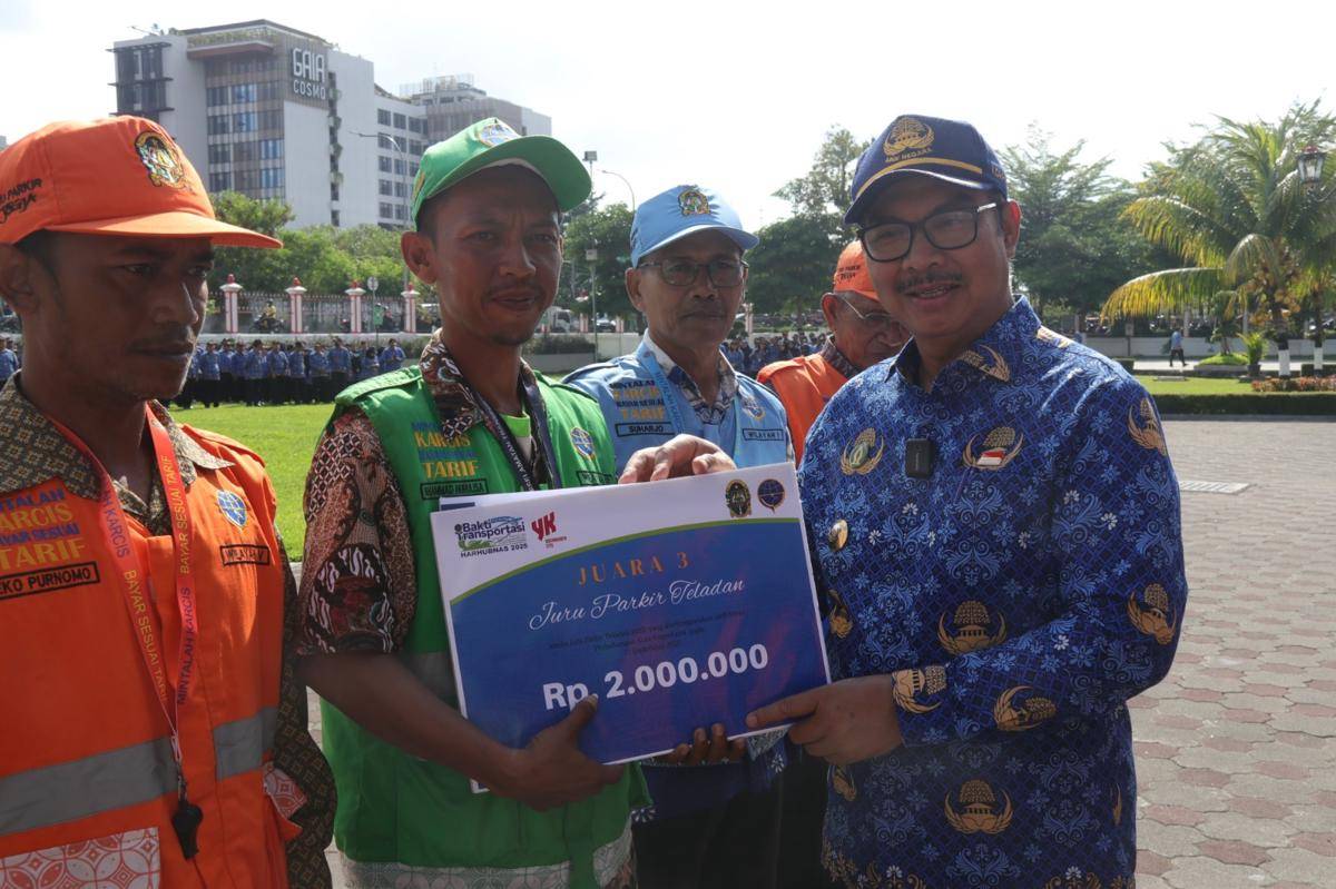Salah satu juru parkir (jukir), Muhammad Nurulisa saat menerima penghargaan. 
