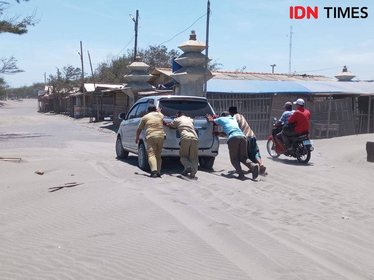 Mobil wisatawan yang terperosok pasir saat melewati jalan di Pantai Parangkusumo