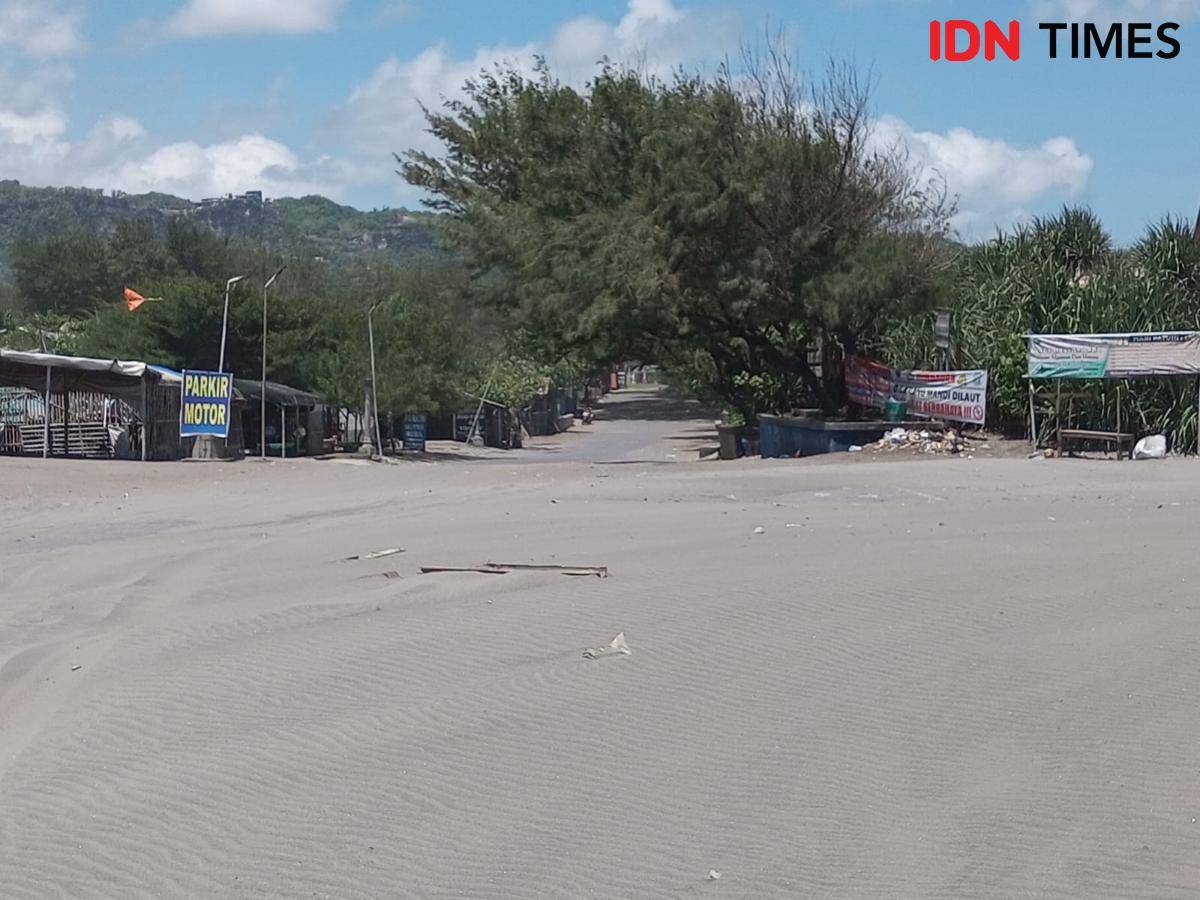 Akses jalan menuju objek wisata Pantai Parangkusumo tertutup pasir.