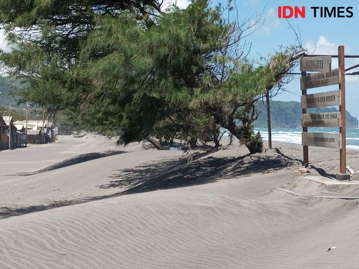 Akses jalan menuju objek wisata Pantai Parangkusumo tertutup pasir