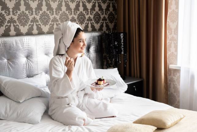 ilustrasi seorang perempuan sedang bersantai di kamar hotel (freepik.com/freepik)