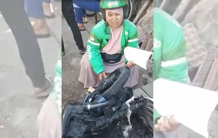 Saripa, pemgemudi ojek online di Makassar menangis meratapi sepeda motor yang hangsu dibakar massa tawuran di Tallo, Selasa (23/9/2025)/Istimewa