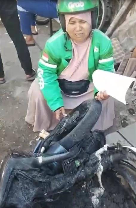 Saripa, pemgemudi ojek online di Makassar menangis meratapi sepeda motor yang hangsu dibakar massa tawuran di Tallo, Selasa (23/9/2025)/Istimewa
