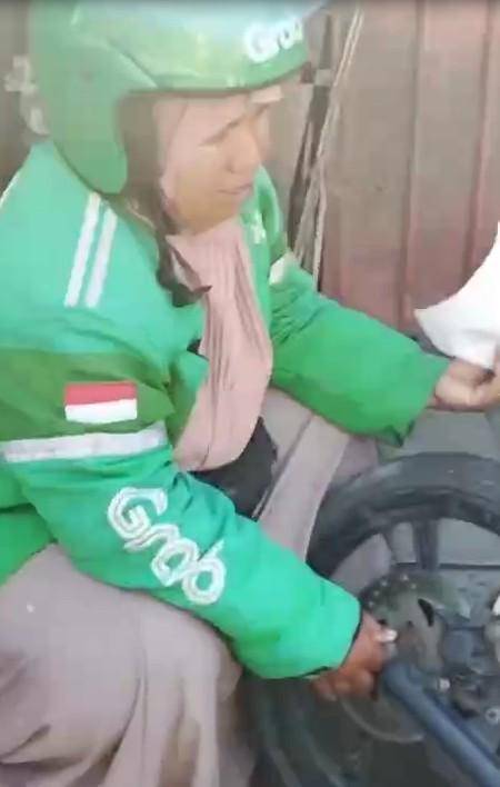 Saripa, pemgemudi ojek online di Makassar menangis meratapi sepeda motor yang hangsu dibakar massa tawuran di Tallo, Selasa (23/9/2025)/Istimewa