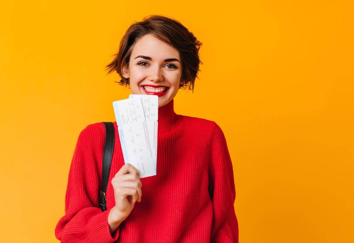 ilustrasi seorang perempuan memegang tiket perjalanan (freepik.com/freepik)
