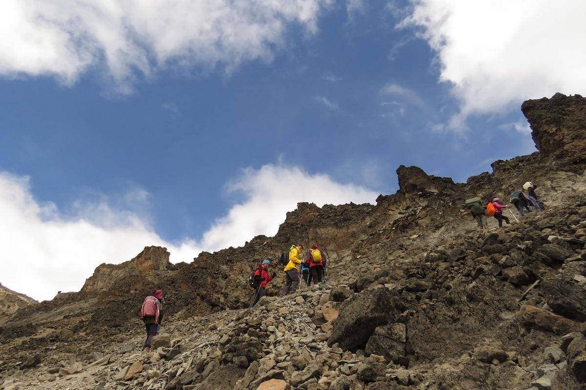 Sekelompok pendaki yang sedang mendaki lereng berbatu di Gunung Kilimanjaro, Tanzania 