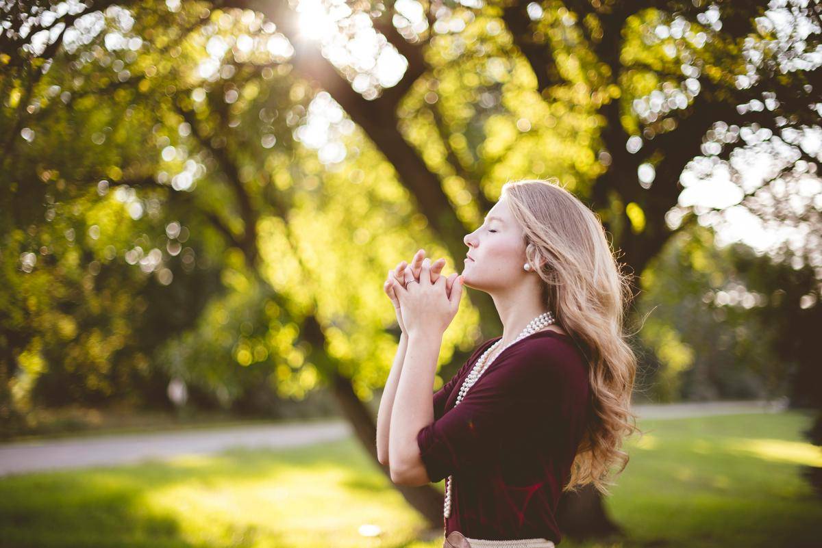 Foto seorang perempuan berdoa di taman. (Unsplash/Ben White)