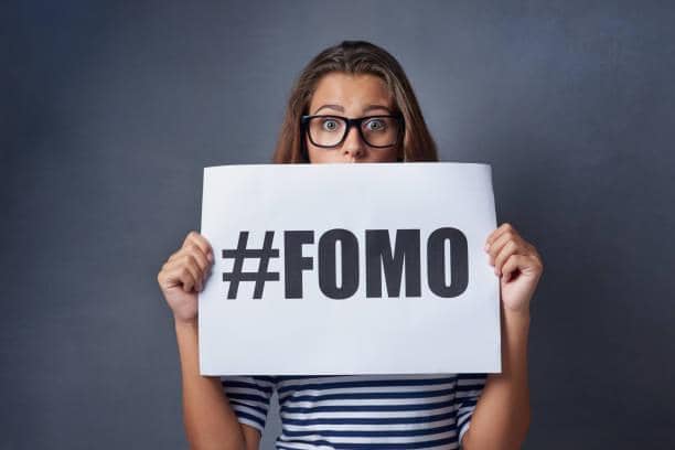 ilustrasi orang memegang tulisan fomo (pexels.com/PeopleImages)