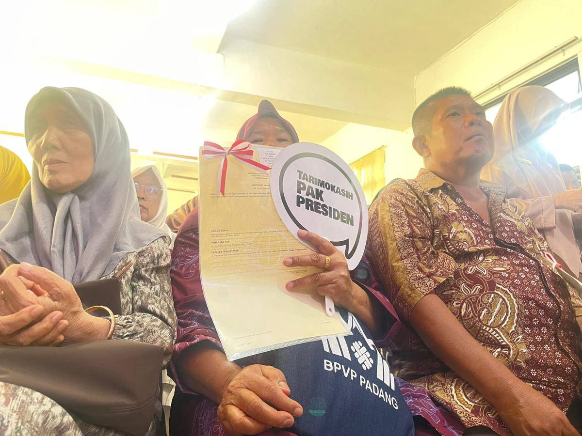 Seorang warga memegang sertifikat yang diberikan oleh Wamen ATR/BPN (Foto: IDN Times/Halbert Caniago)