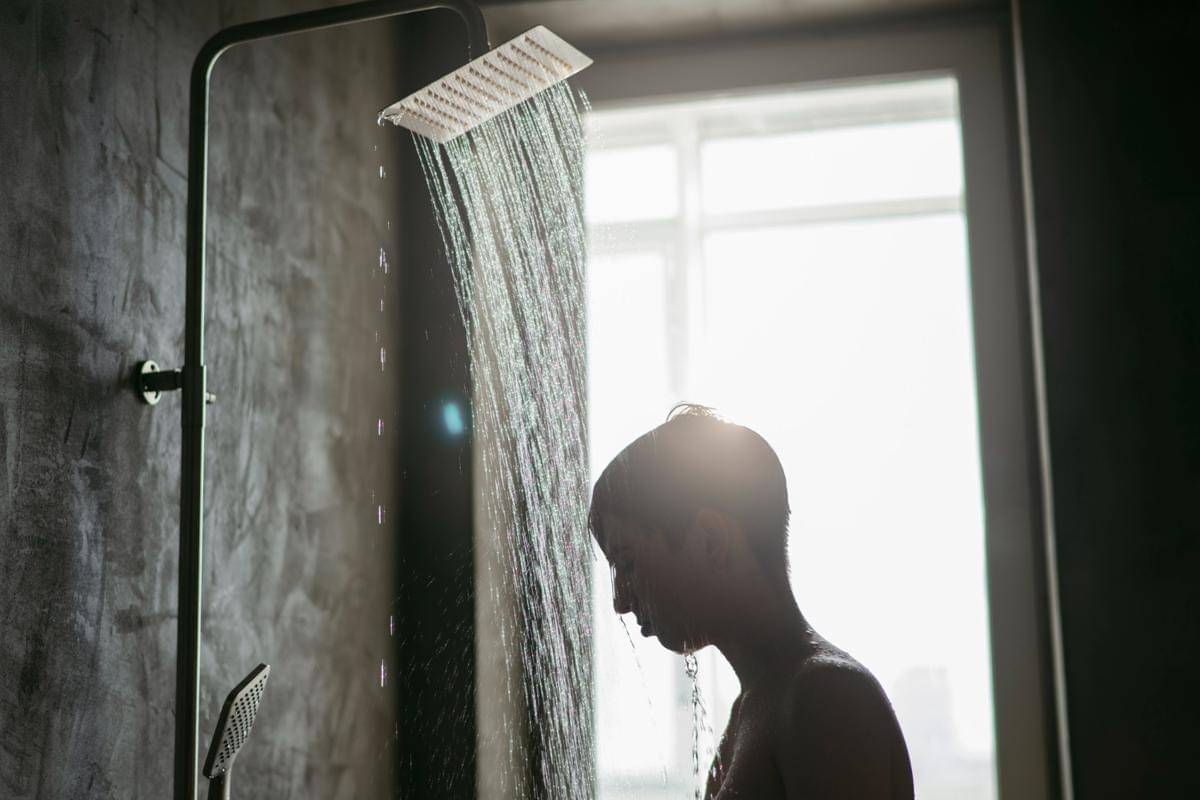 Ilustrasi seorang laki-laki mandi di bawah pancuran.