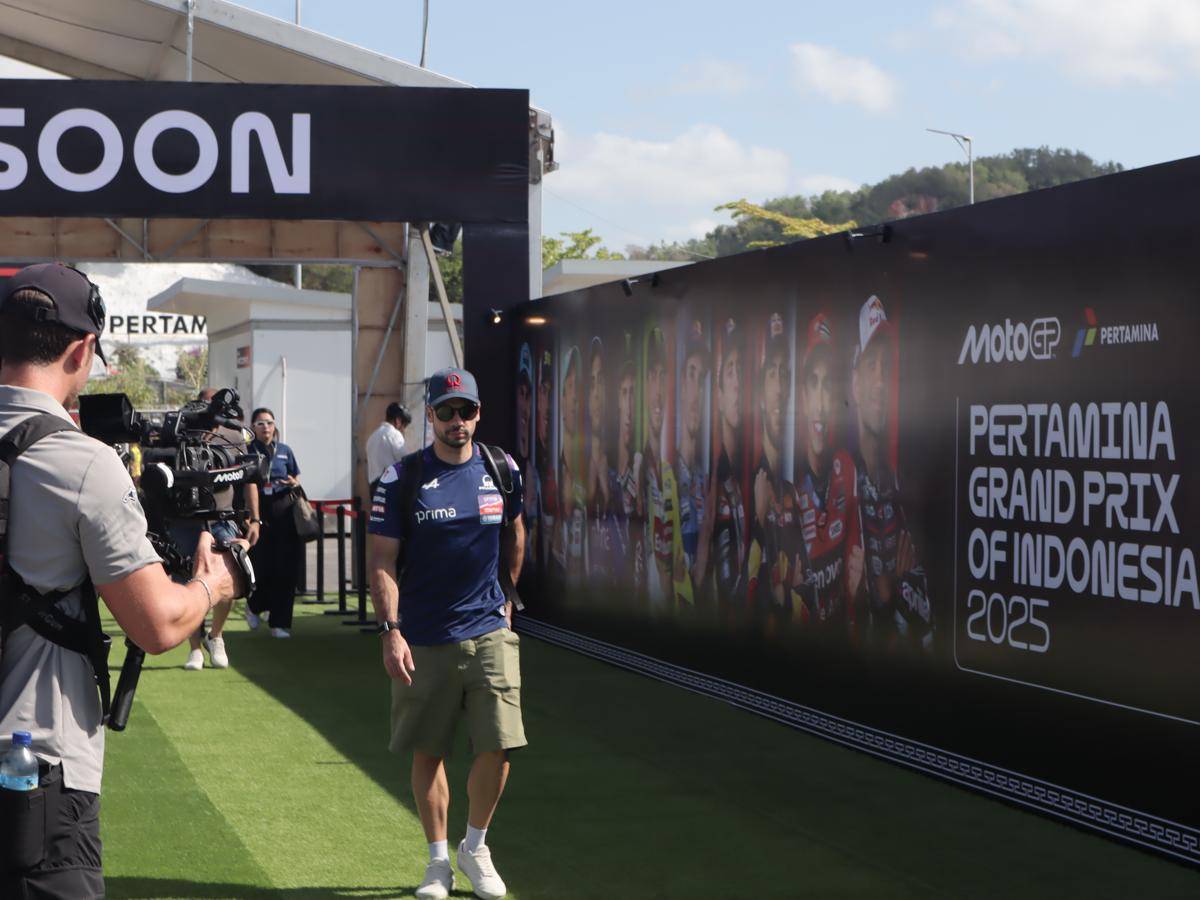 Pembalap MotoGP, Miguel Oliveira tiba di Sirkuit Mandalika membawa ransel hitam. Ia juga mengenakan kacamata hitam. Outfitnya semakin terlihat santai karena dilengkapi dengan topi bertuliskan Pramac. (IDN Times/Linggauni)