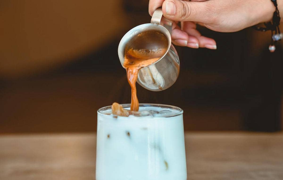 ilustrasi menuang espresso di atas susu