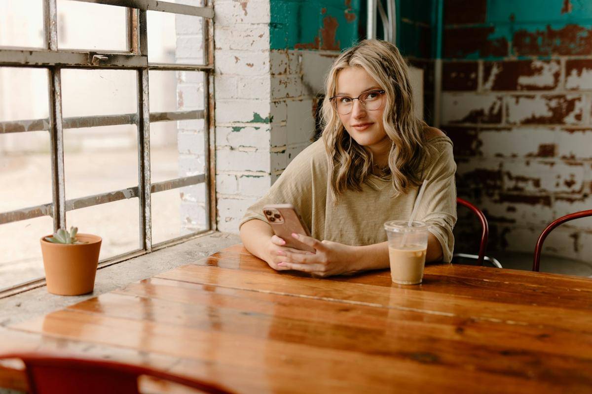 ilustrasi perempuan memegang ponsel (unsplash.com/Brooke Cagle)