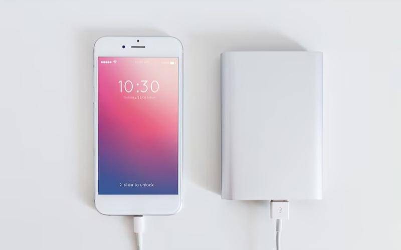 ilustrasi HP sedang diisi daya memakai power bank 