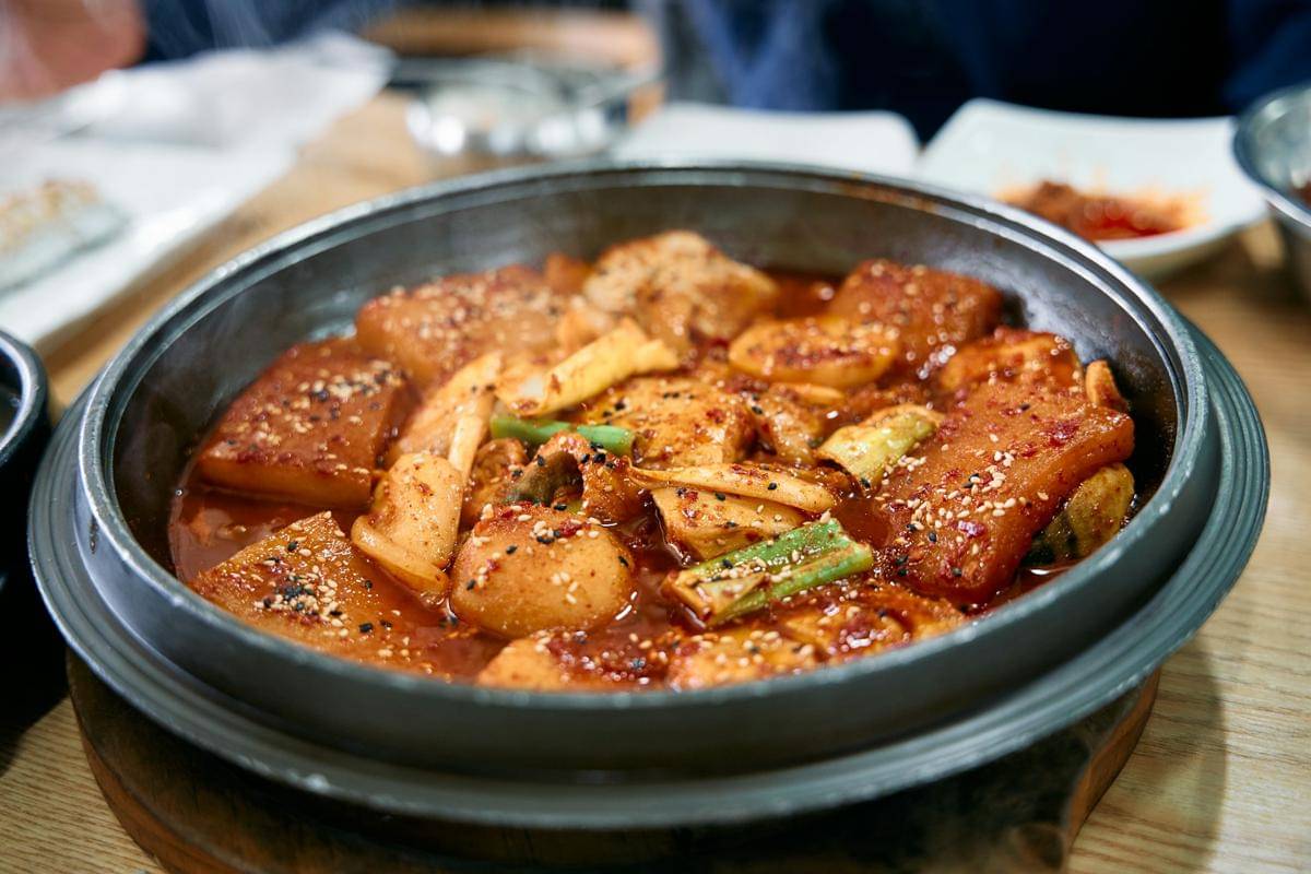 ilustrasi spicy fish cake tteokbokki yang siap untuk disajikan