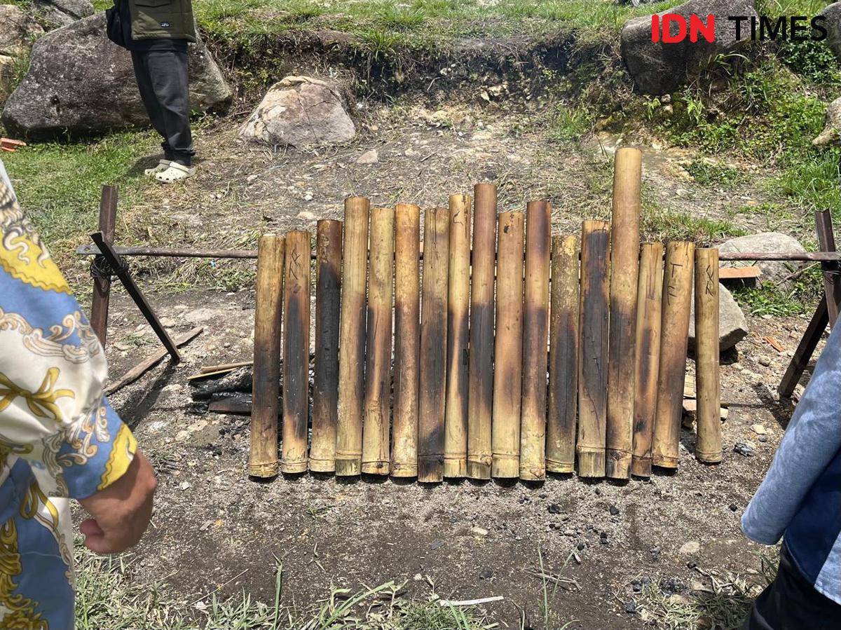 Warga membakar lemang di pinggir danau 