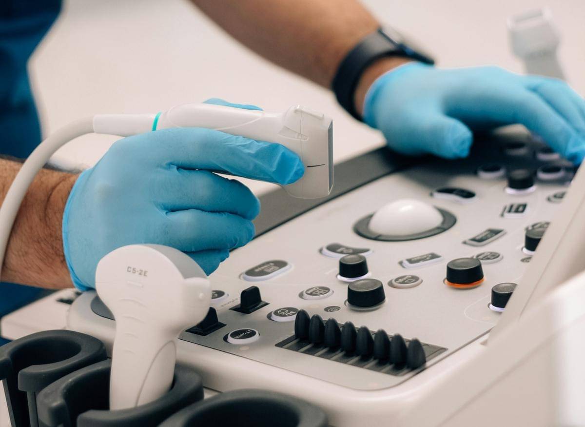 Dokter memegang probe, bersiap akan melakukan tes ultrasound (USG).