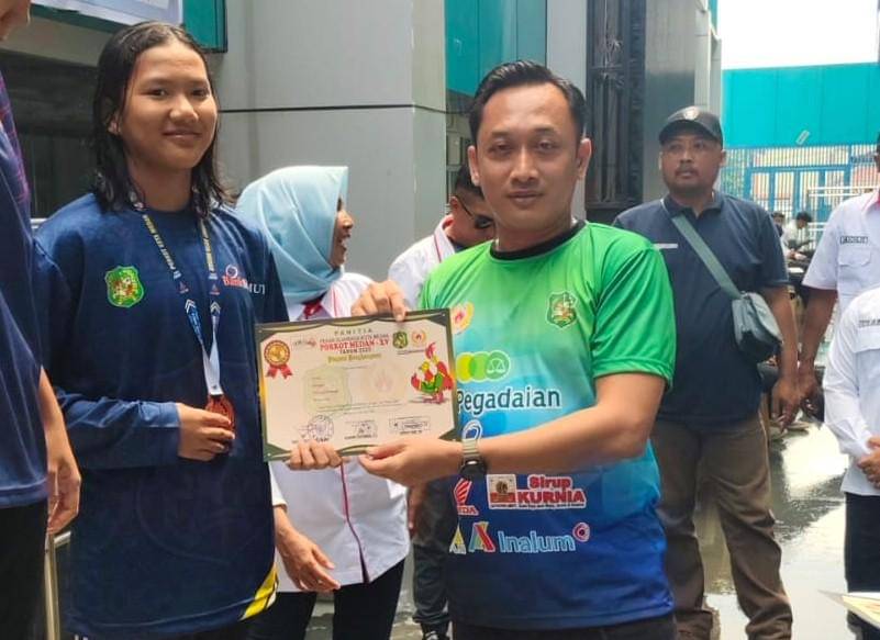 Ketua KONI Medan Aswindy menyerahkan medali kepada atlet renang Porkot Medan 2025 (dok.media porkot)