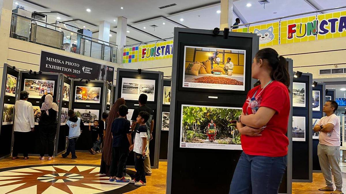 Warga masyarakat Mimika melihat sejumlah foto yang dipamerkan dalam kegiatan Mimika Photo Exhibition 2025 di Lantai II Diana Mall Timika, Senin (13/10/2025). (IDN Times/Endy Langobelen)