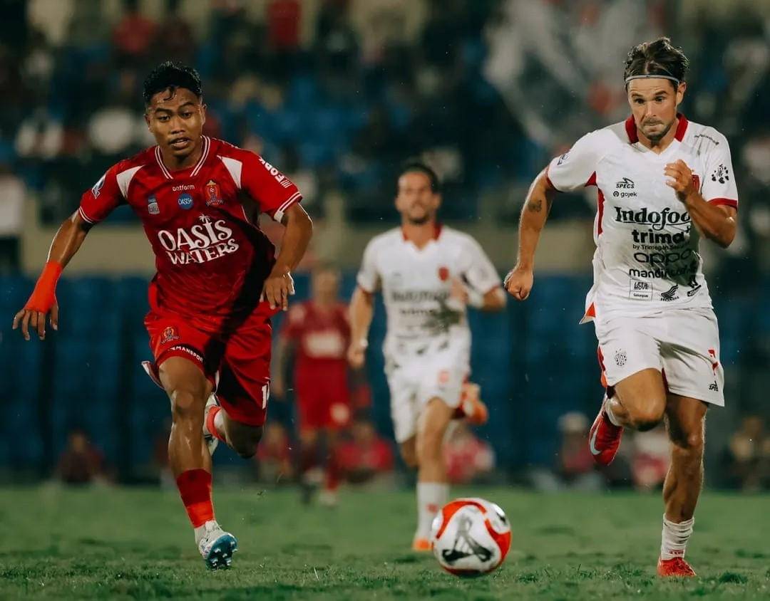 Pemain Bali United (putih) mendapatkan pengawalan dari pemain Persijap Jepara (merah).