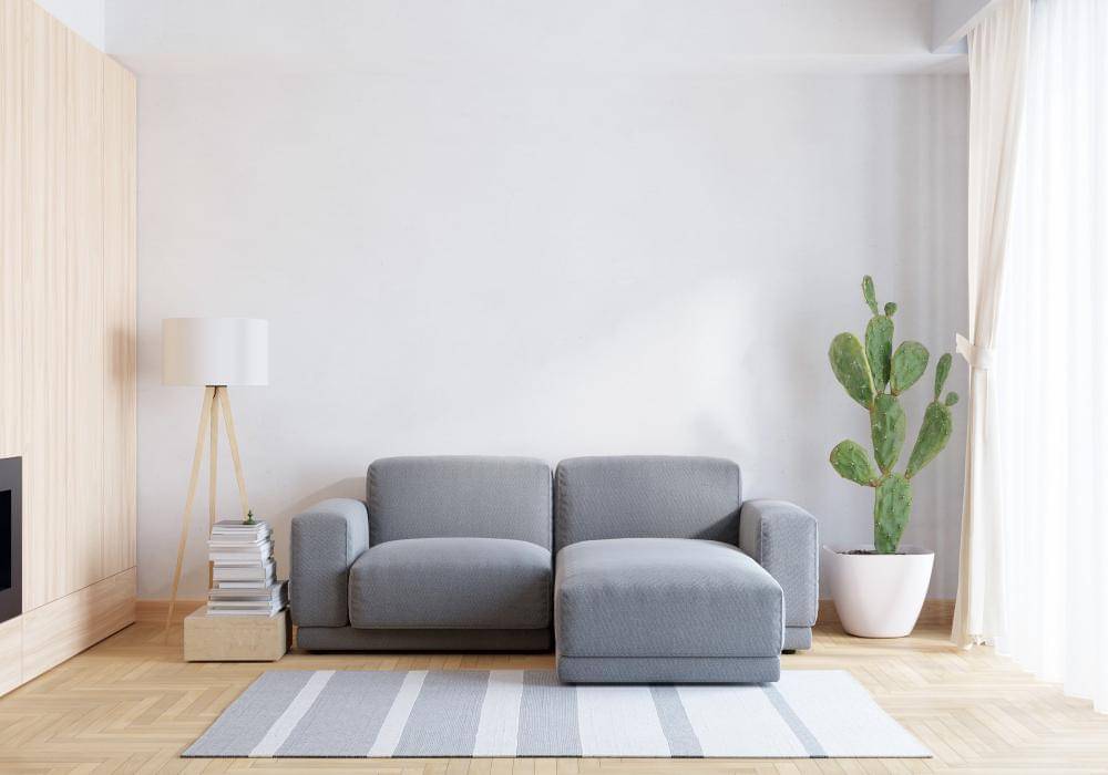 Sofa abu-abu di ruang tamu berwarna putih