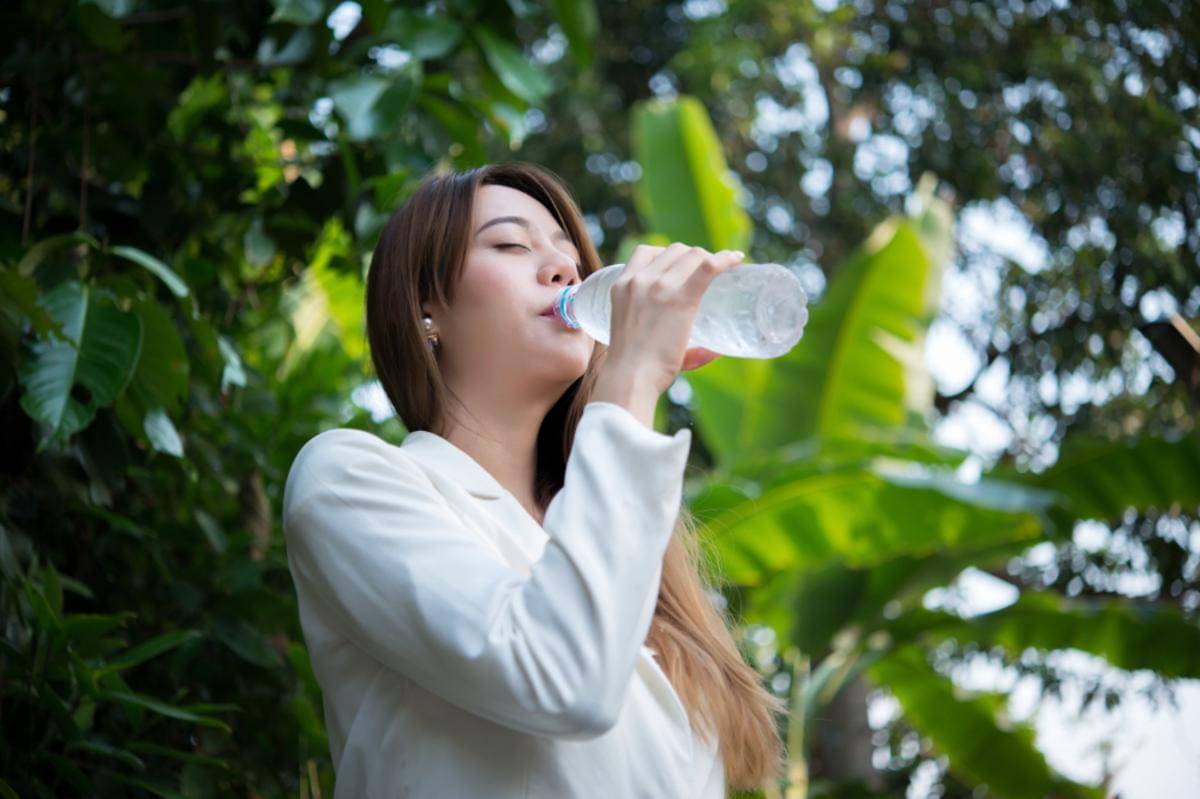 Ilustrasi seorang perempuan sedang minum air mineral