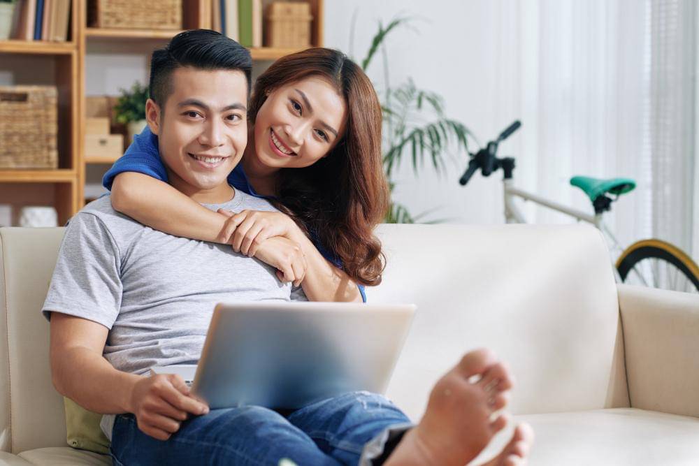Seorang perempuan memeluk seorang laki-laki dengan bahagia.