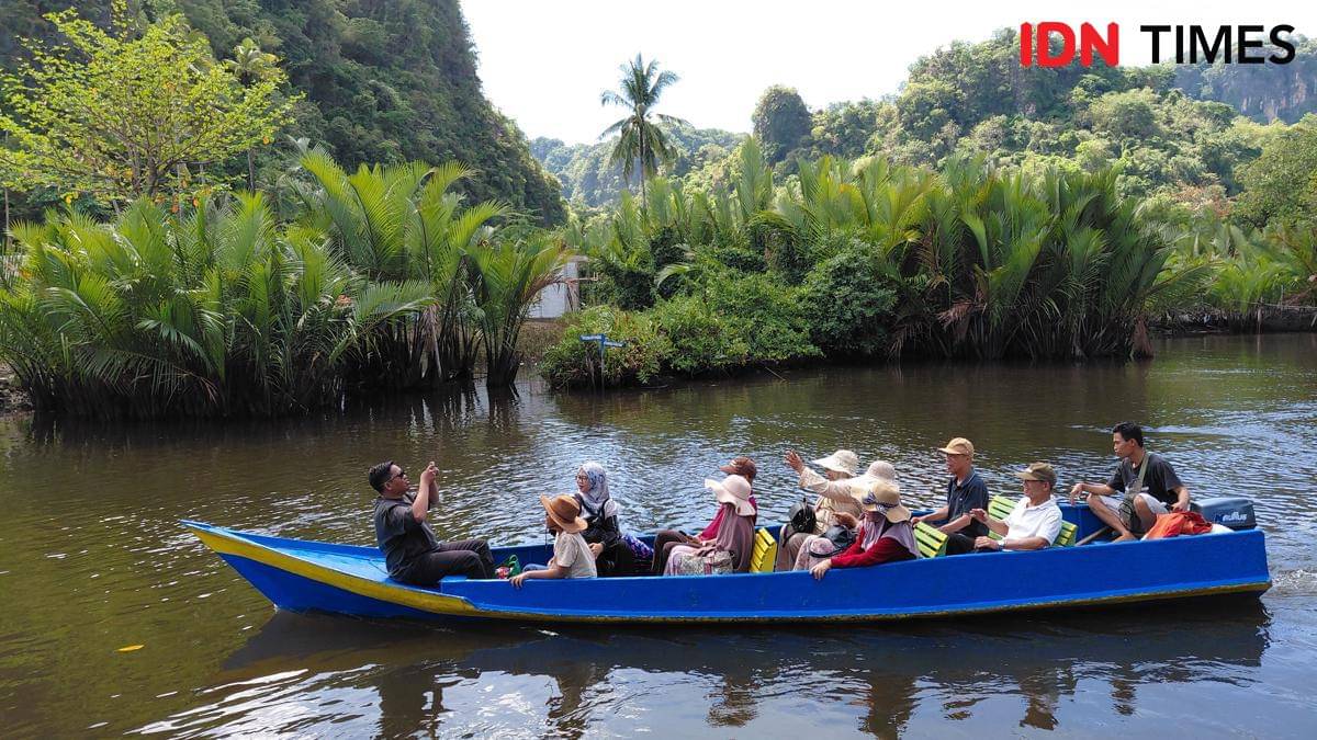 Wisatawan menyusuri Sungai Pute dengan perahu listrik di kawasan karst Rammang-Rammang, Kabupaten Maros, Sulawesi Selatan. (IDN Times/Aan Pranata)