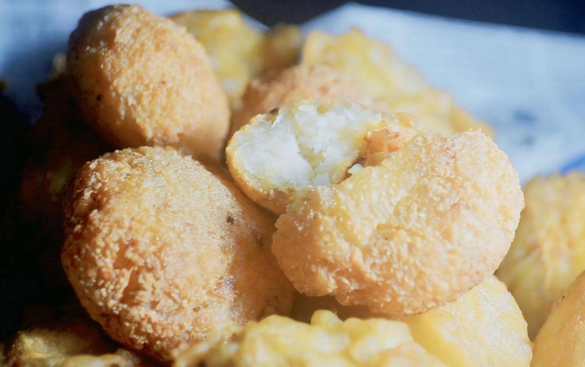 Beberapa potong combro goreng berwarna keemasan dengan satu potong terbuka memperlihatkan isian oncom di bagian dalamnya.