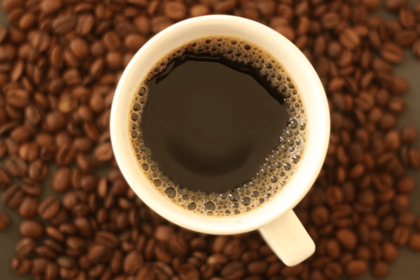 ilustrasi secangkir kopi hitam dan biji-biji kopi 