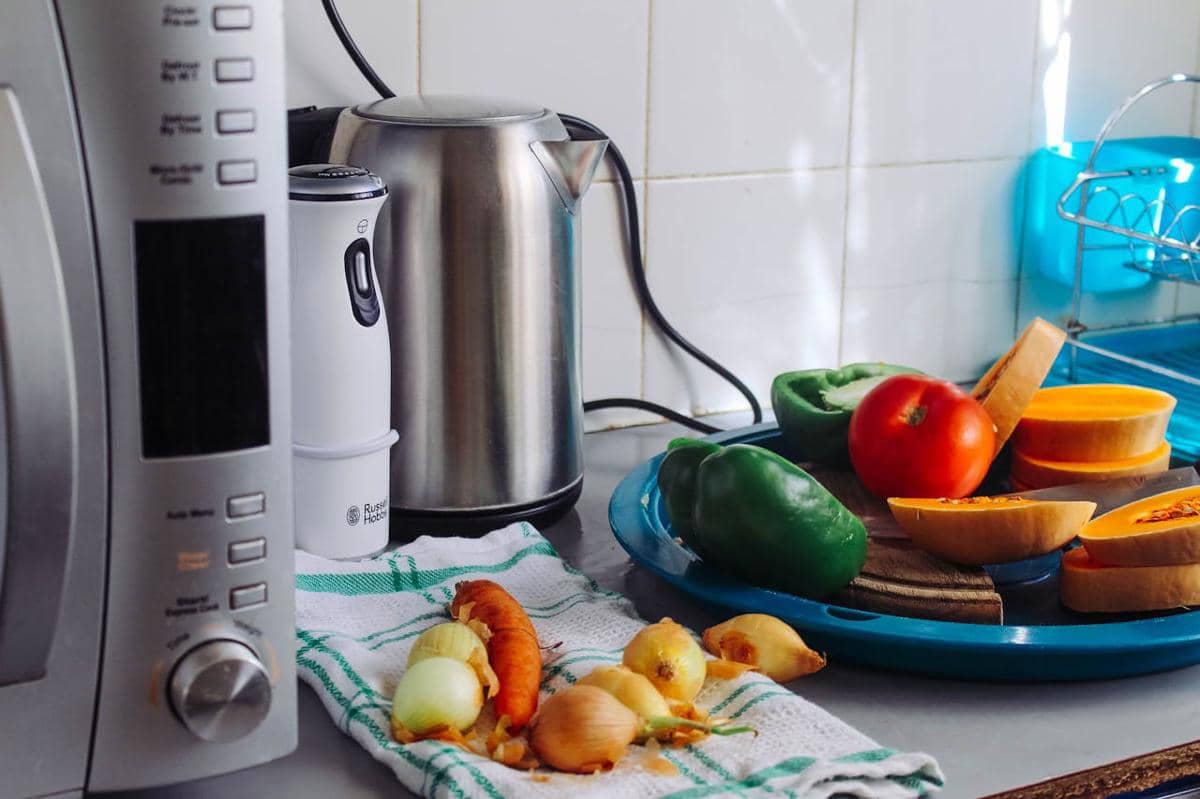 Aneka peralatan elektronik dapur tersusun rapi di atas meja sebagai ilustrasi kebutuhan memasak modern.