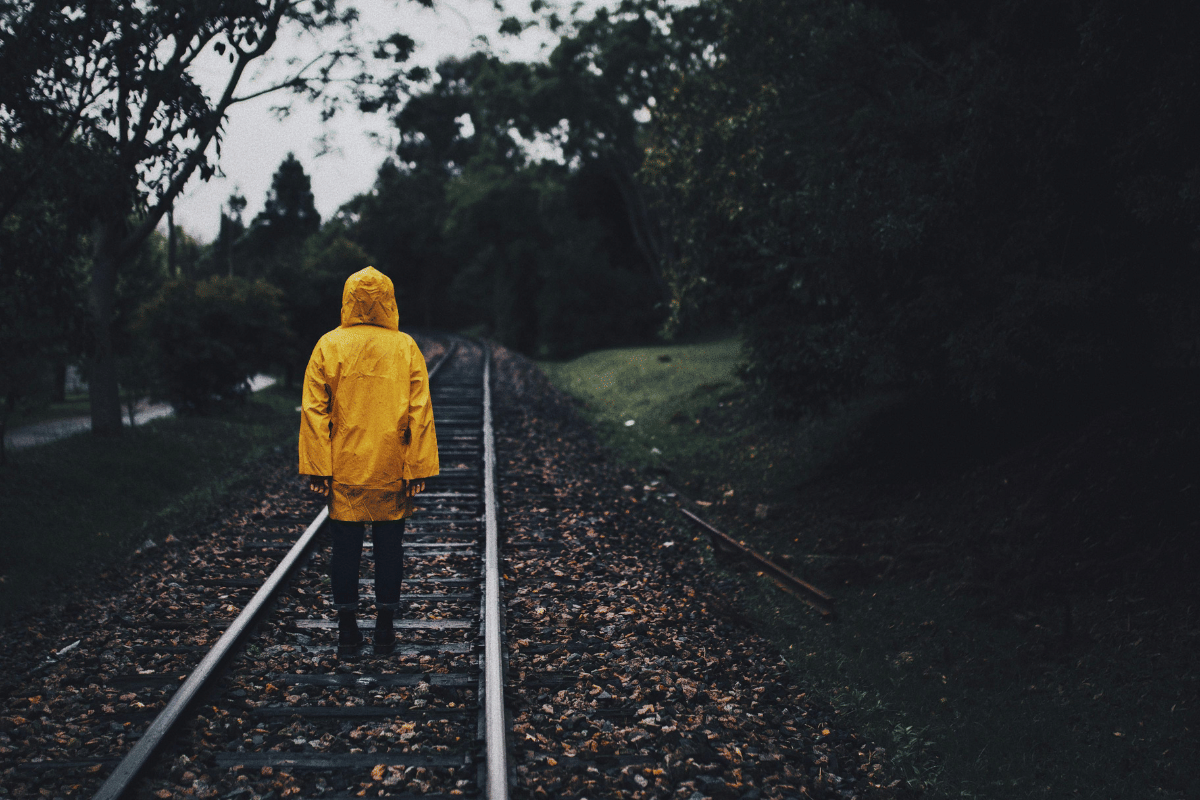 Foto orang yang berdiri di rel kereta