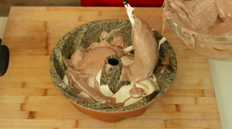 ilustrasi menuang adonan bolu marmer cokelat meses ke dalam loyang