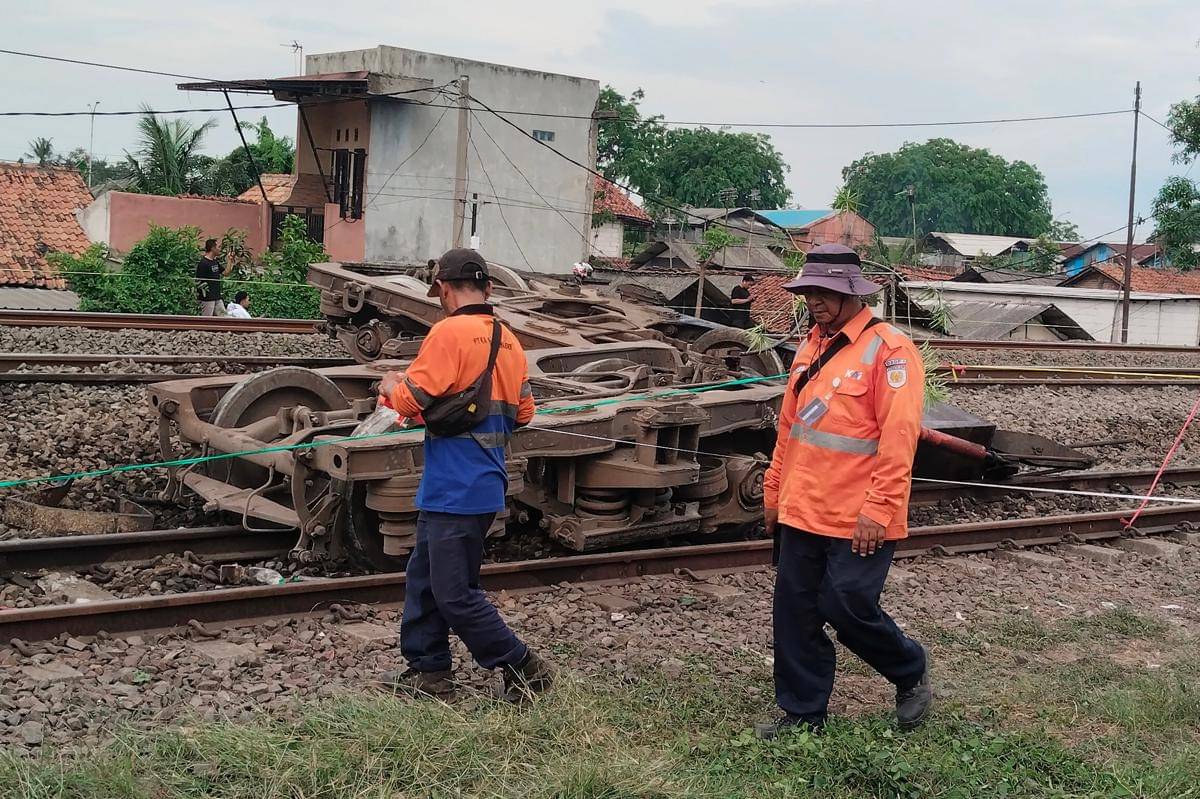 Petugas melintas di samping bagian roda Kereta Api Purwojaya relasi Gambir Kroya saat mengalami anjlok di Emplasemen Stasiun Kedunggedeh, Kabupaten Bekasi, Jawa Barat, Sabtu (25/10/2025). (ANTARA FOTO/M Ali Khumaini)